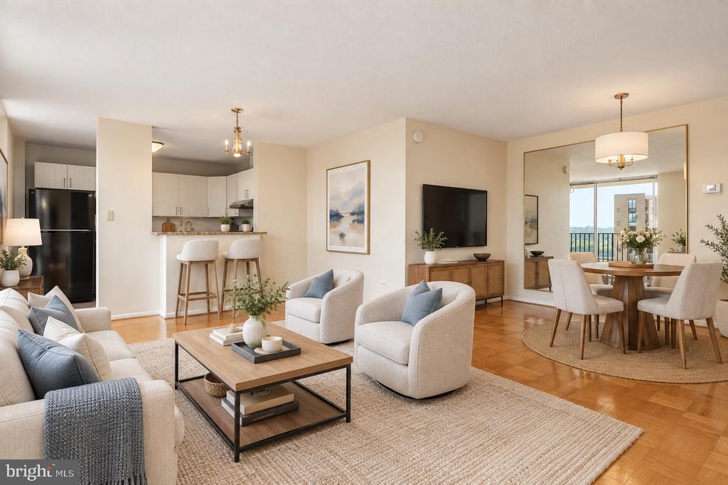 Open-plan condo living room with a beige sofa, wood coffee table, and dining area beside the balcony.