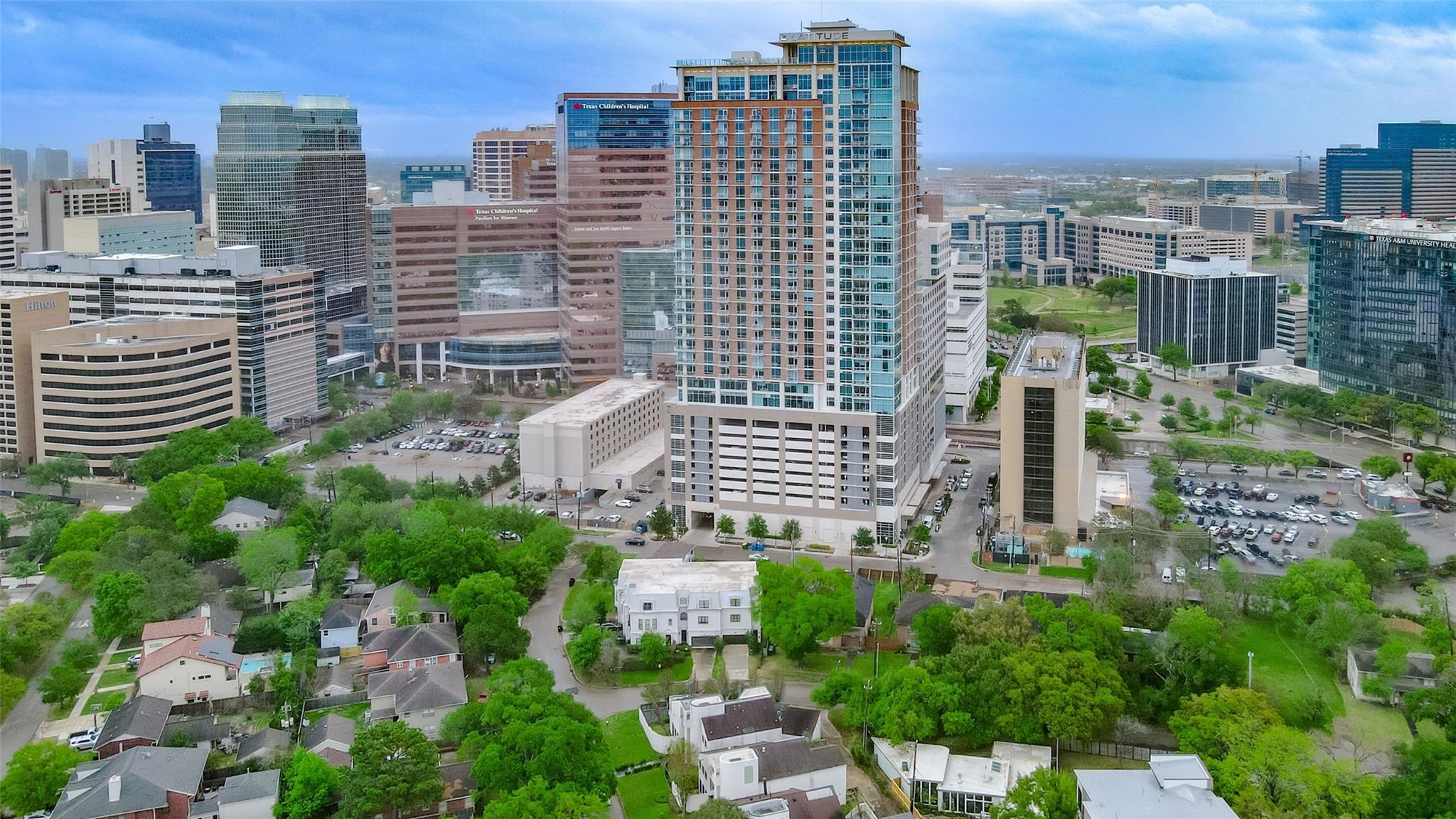 Aerial view of Houston’s medical district, with high-rises behind tree-lined streets and homes.