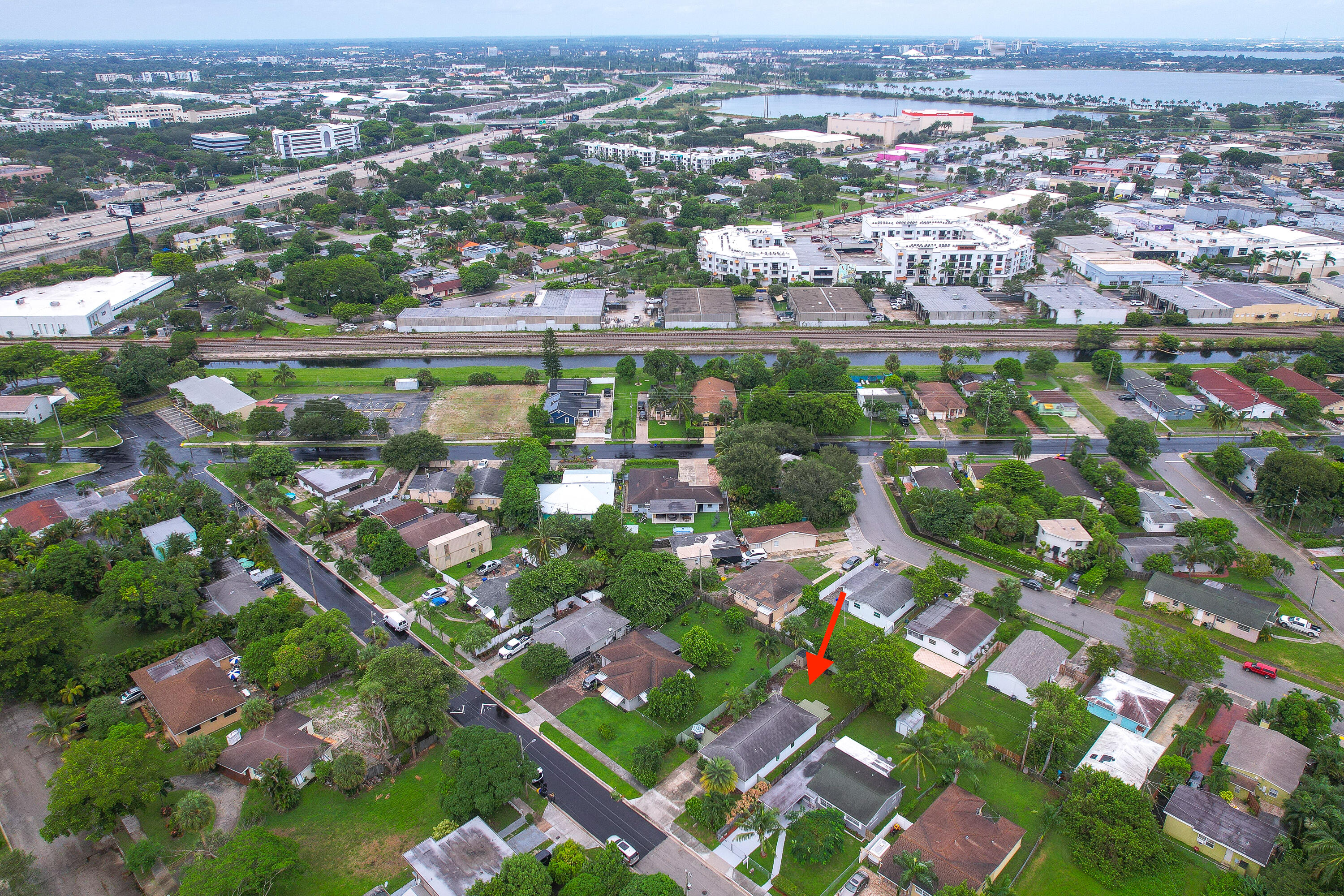 Aerial view of the Charles Street property, marked by a red arrow amid a palm-lined neighborhood.