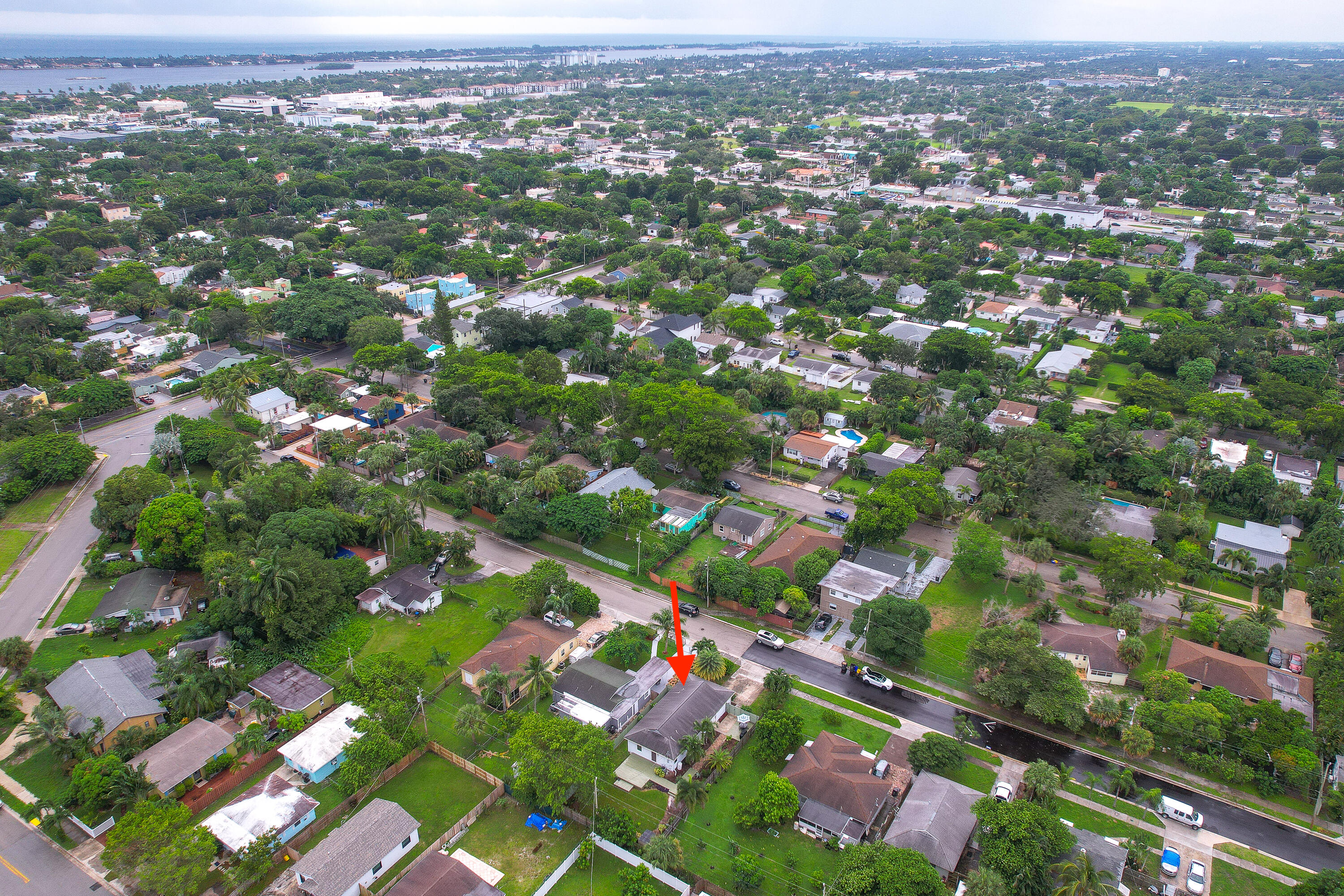 Aerial view of the property marked by a red arrow, with a waterway in the distance.