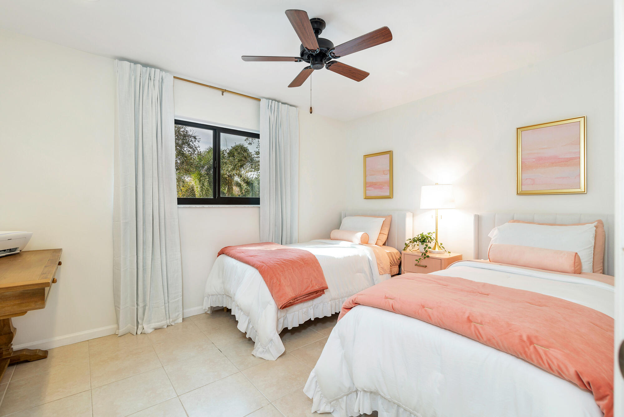 Bedroom with two twin beds dressed in white and coral-pink linens.