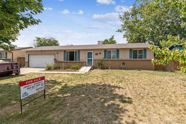 Single-story brick ranch home with an attached garage and a for-sale sign in the front yard.