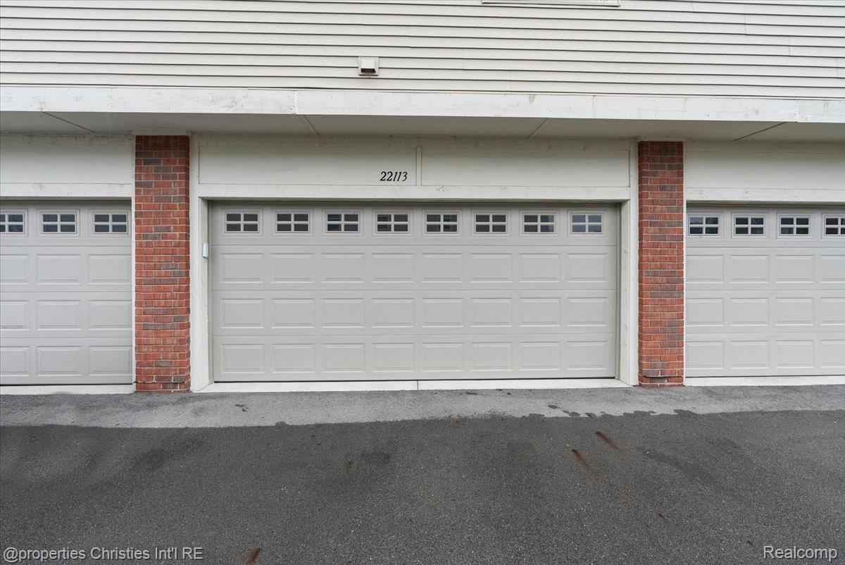 White paneled garage door marked 22113, framed by red brick columns.