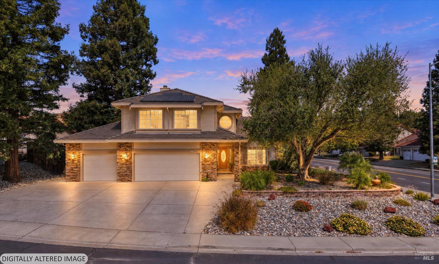 Two-story home at dusk with stone accents, solar panels, a double garage, and landscaped front yard.