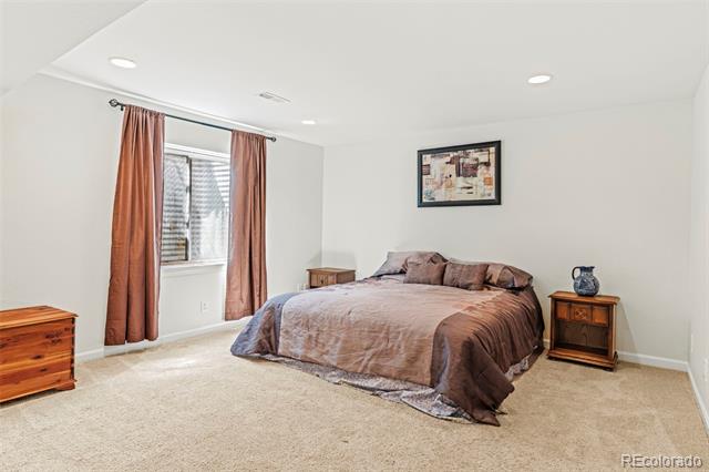 Bedroom with mauve bedding, rust-colored curtains, and wooden nightstands.