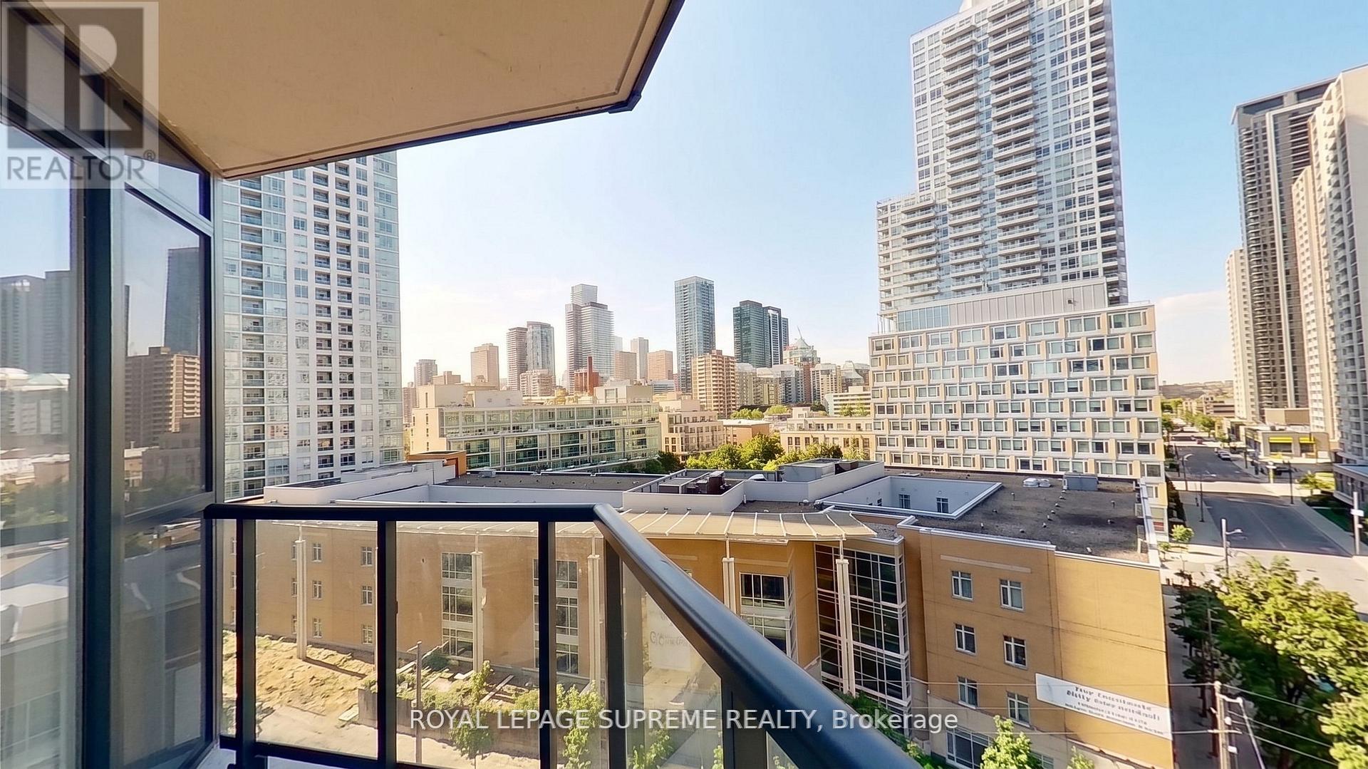 City skyline viewed from a high-rise condo balcony with a glass railing.