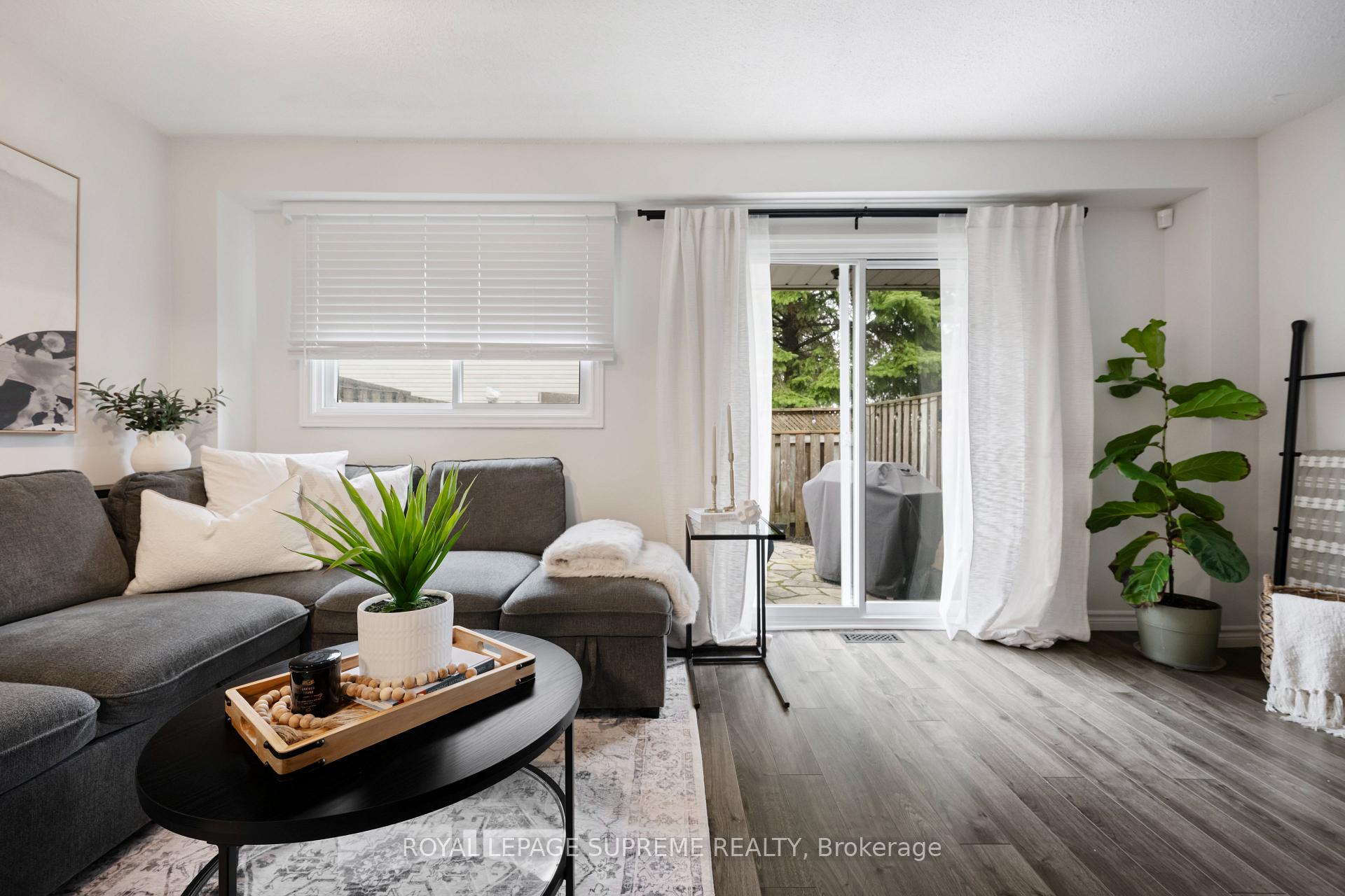 Living room with a gray sectional and sliding doors opening to a fenced patio.