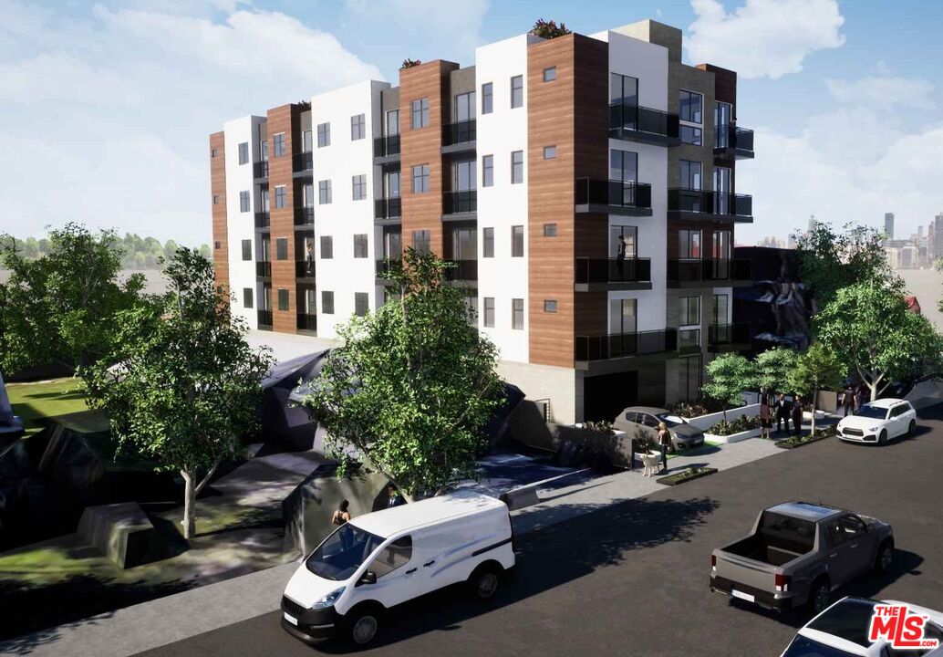 Modern apartment building with glass balconies and landscaped street frontage