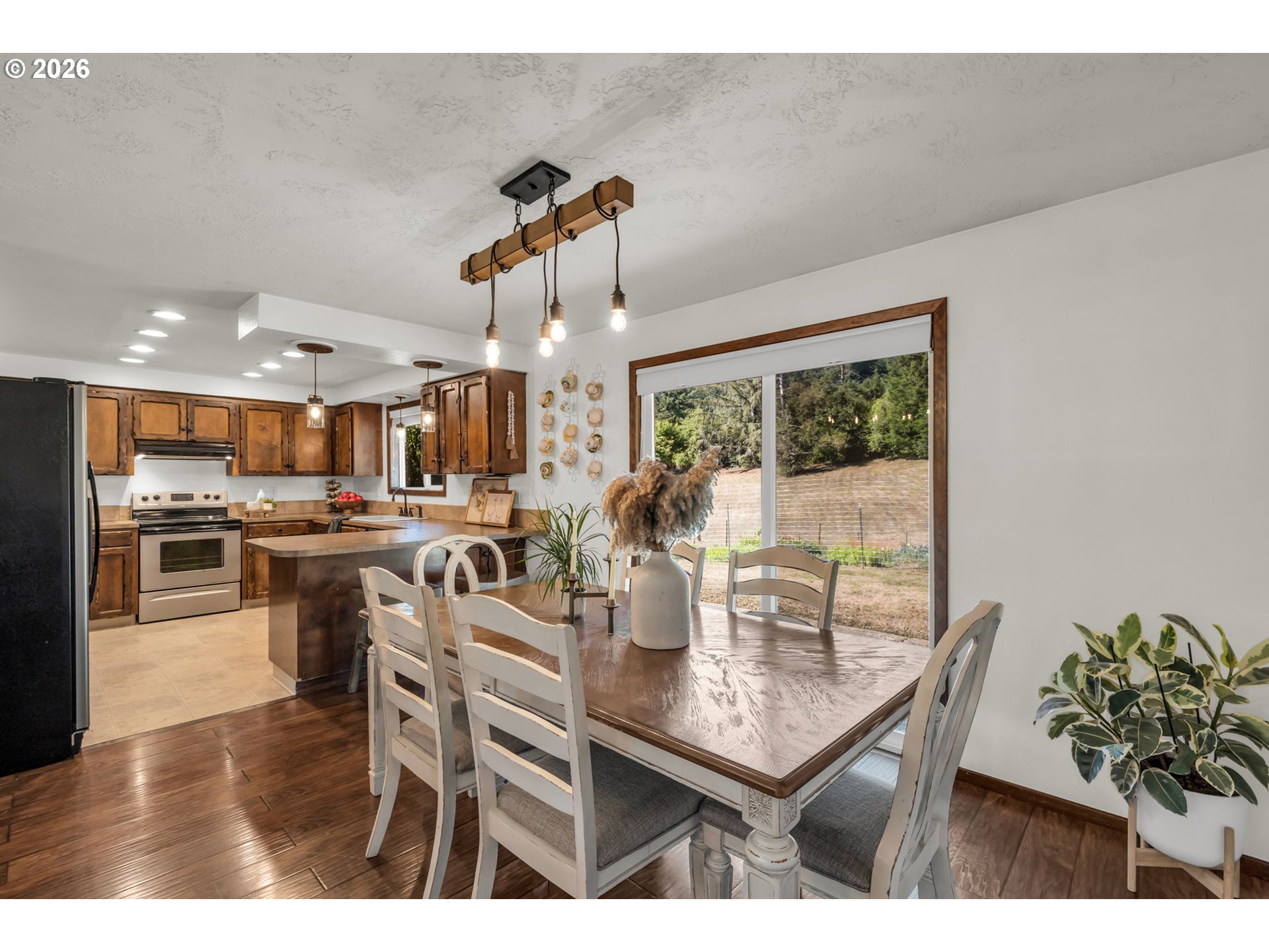 Kitchen and dining area with wood cabinets, a large table, and sliding doors to the yard.