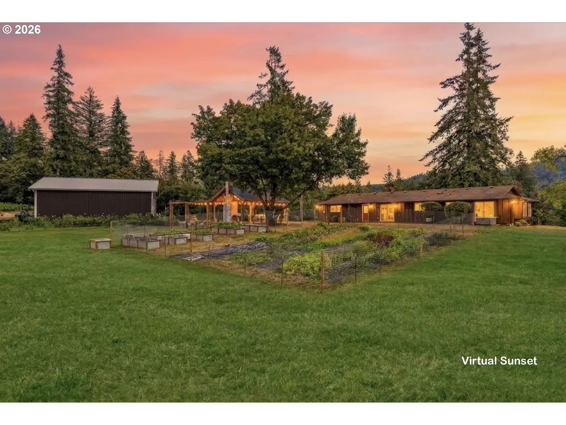 Single-story home and outbuilding beside fenced garden beds, shown at sunset.