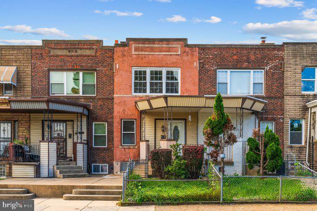 Brick rowhouses with covered entryways and small fenced front yards.