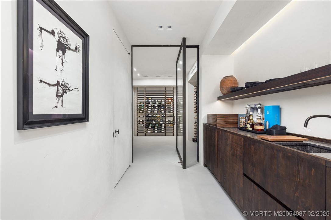 Wine cellar with glass-fronted bottle racks and a dark wood bar.