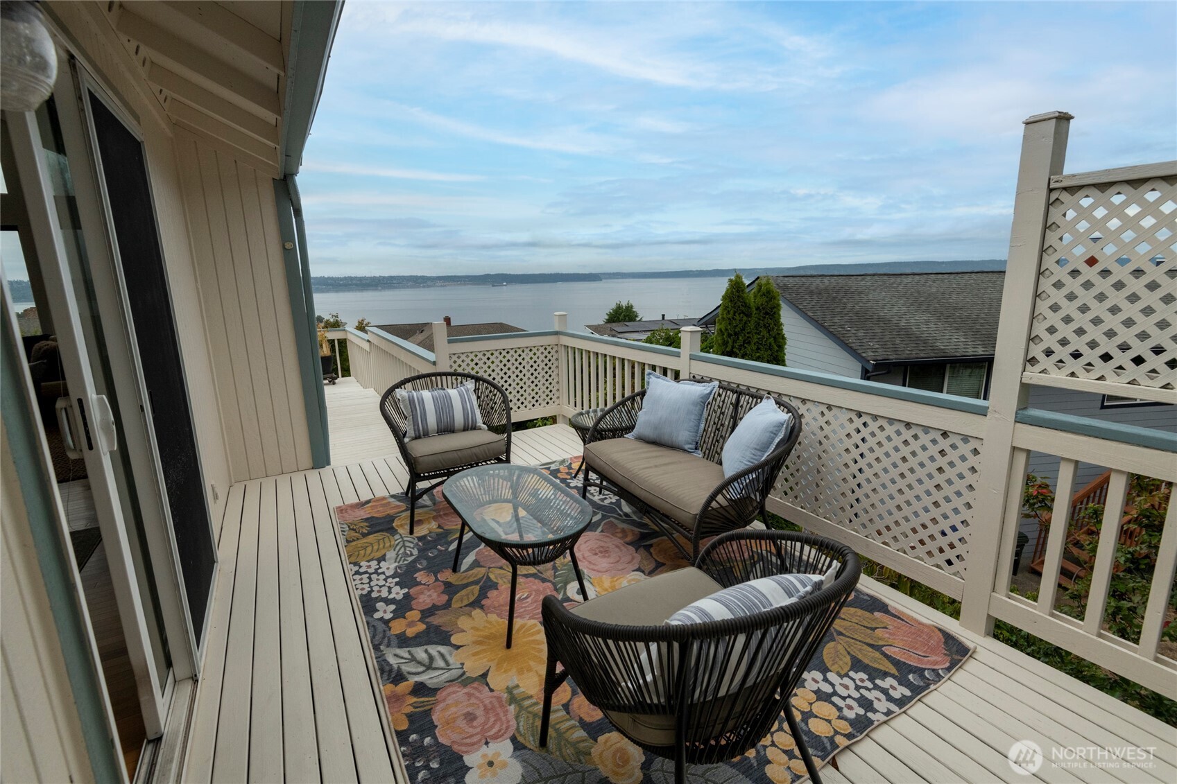 Furnished deck with wicker seating and a water view.