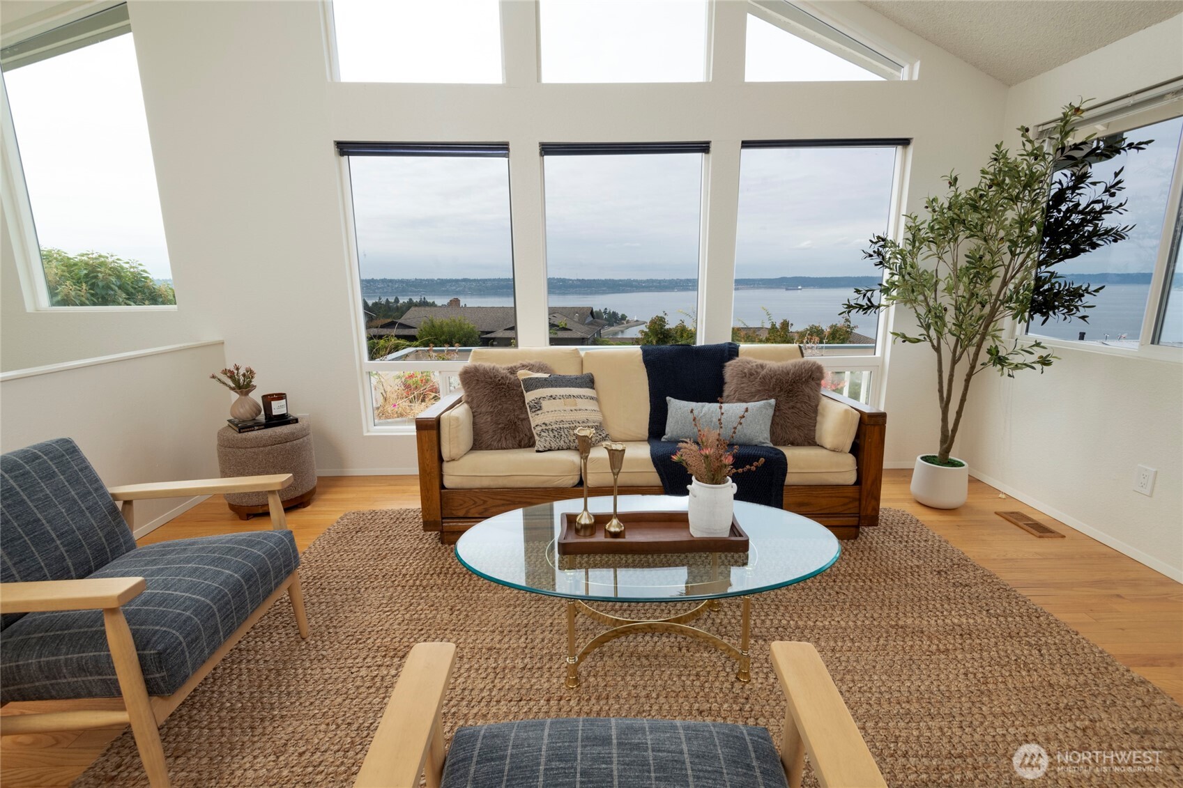 Staged living room with expansive water views through large windows.
