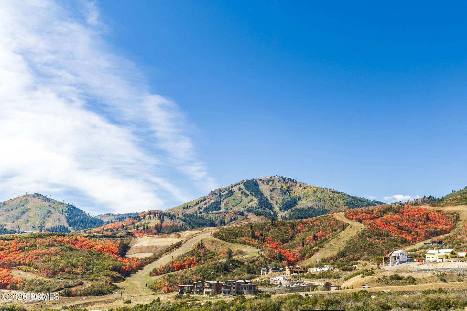 Mountain view over autumn-colored hills, with homes in the foreground.