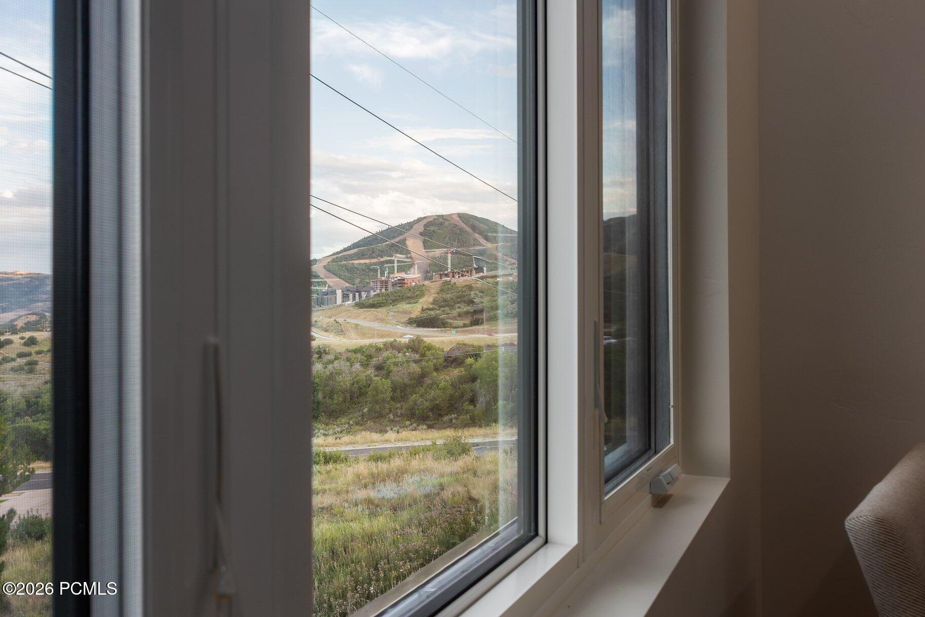 Mountain ski slopes and resort buildings viewed through tall windows.