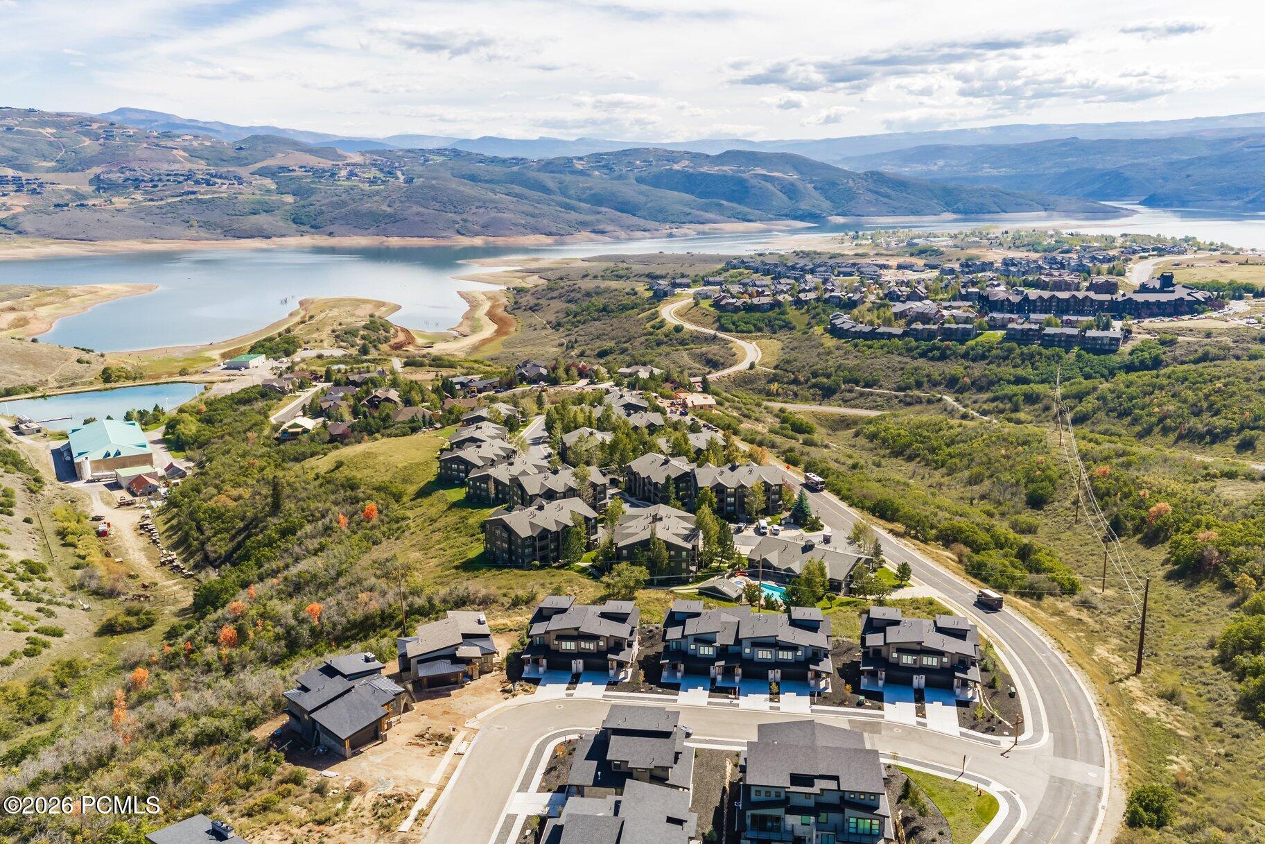 Aerial view of homes beside a reservoir, with mountain ridges in the distance.