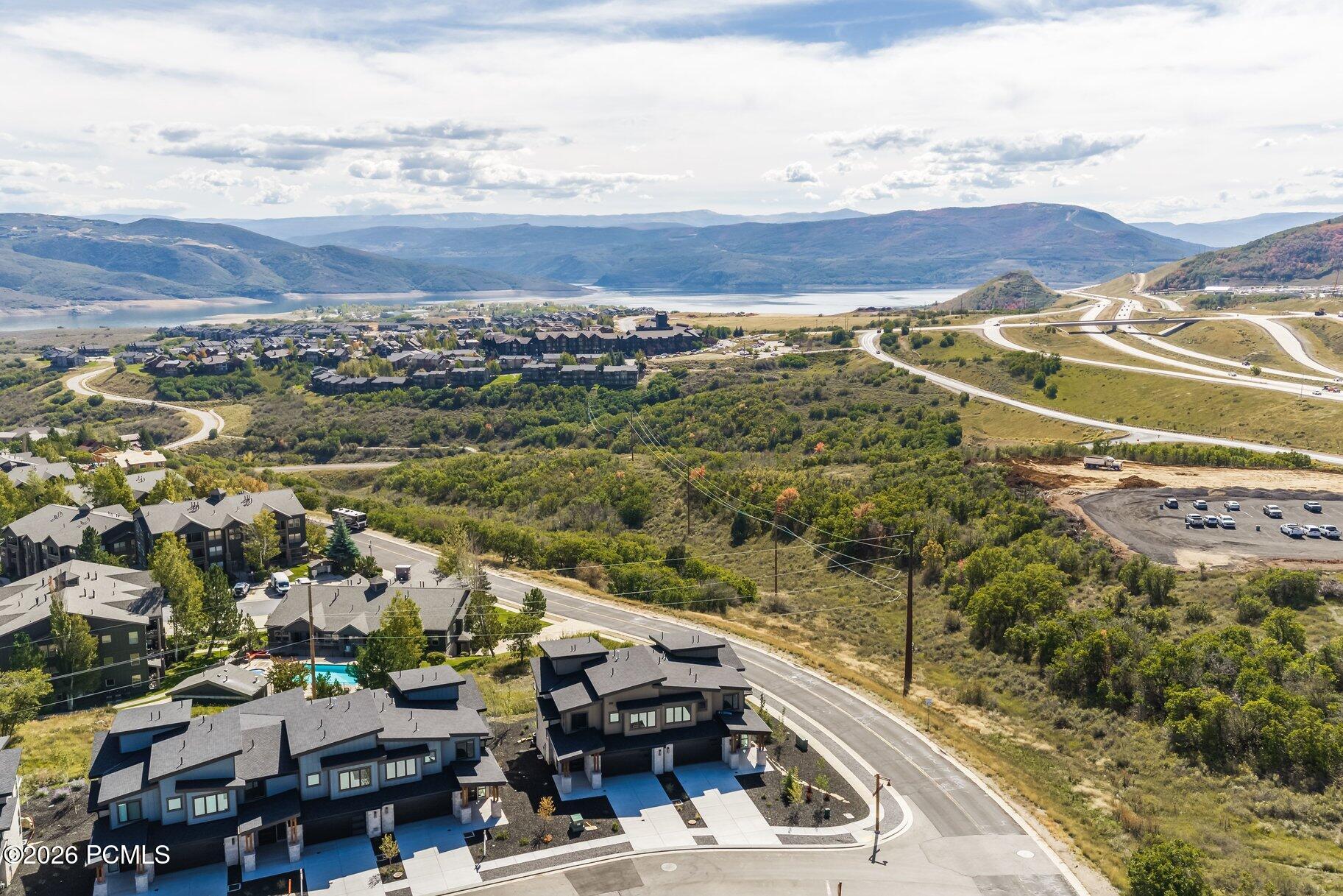 Aerial view of neighborhood homes, a reservoir, and mountain ranges.