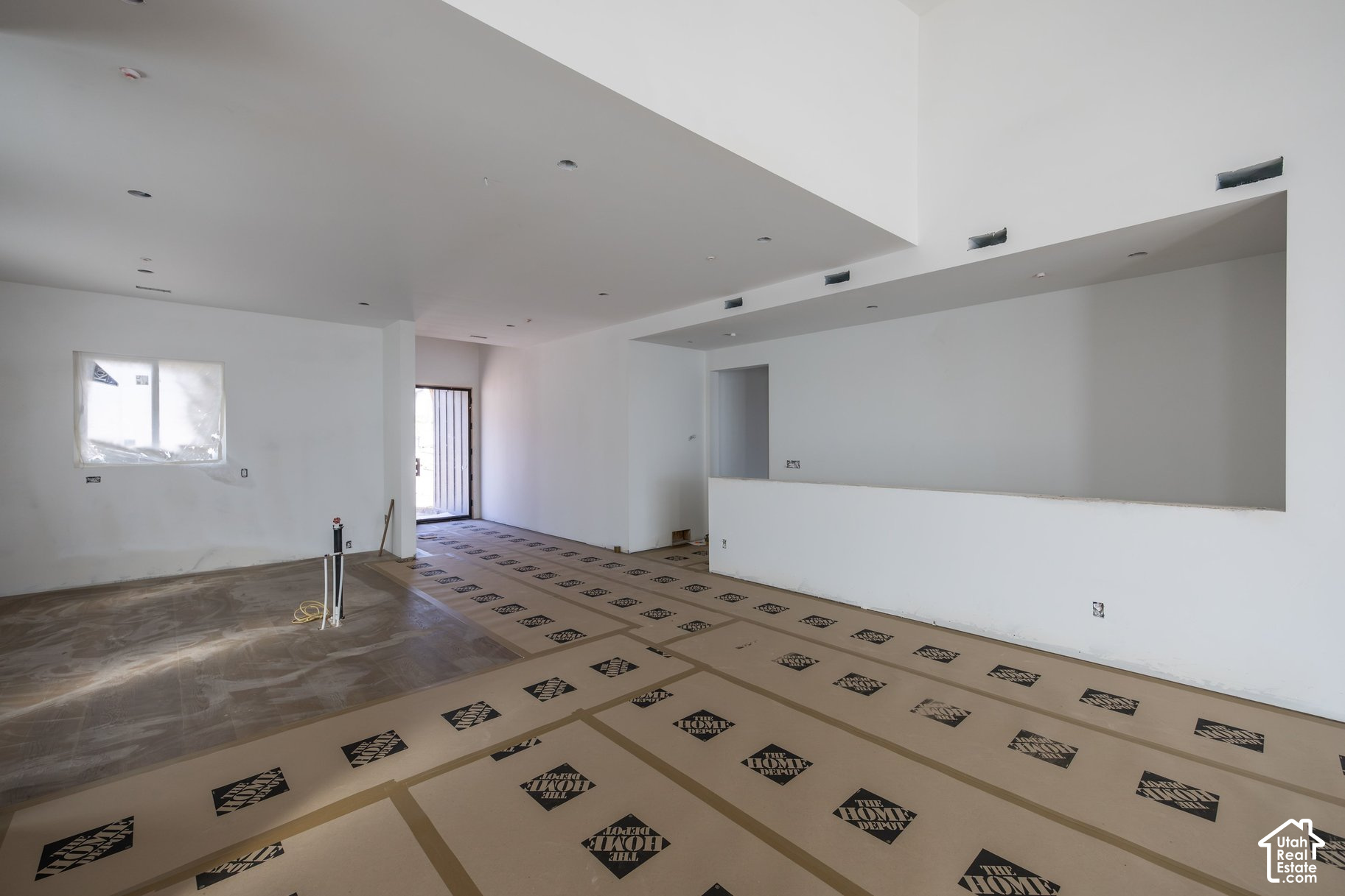 Unfinished open-plan interior with a large pass-through counter and protective floor covering.