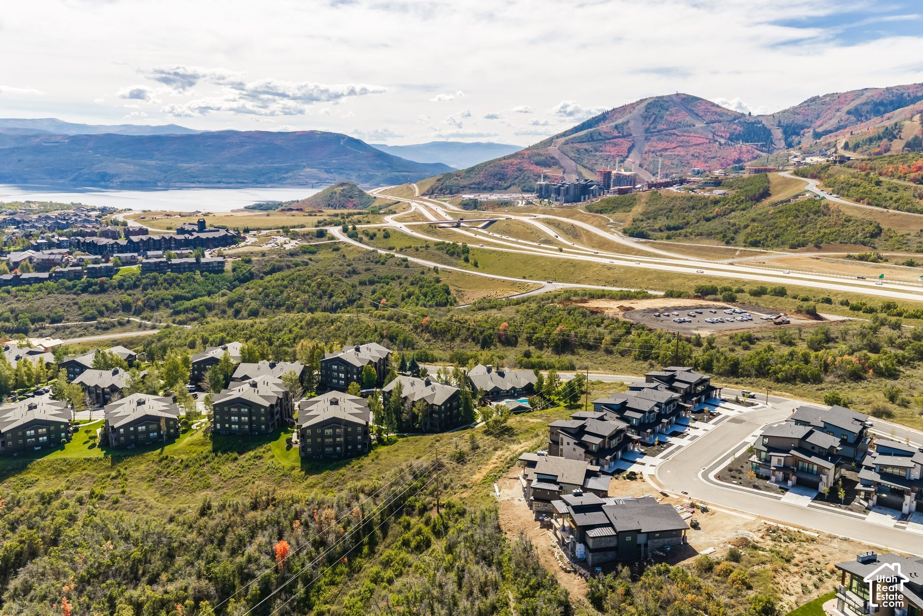 Aerial view of a Heber City development, with mountain slopes, a reservoir, and homes.