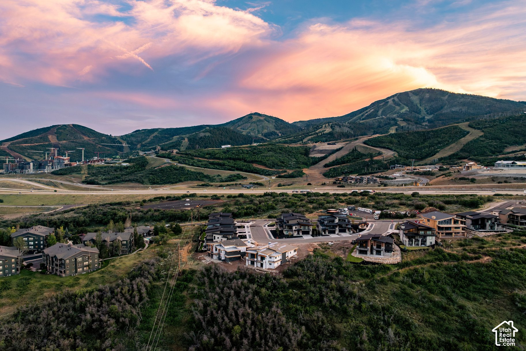 Aerial view of Heber City homes and construction sites with mountain slopes in the distance.