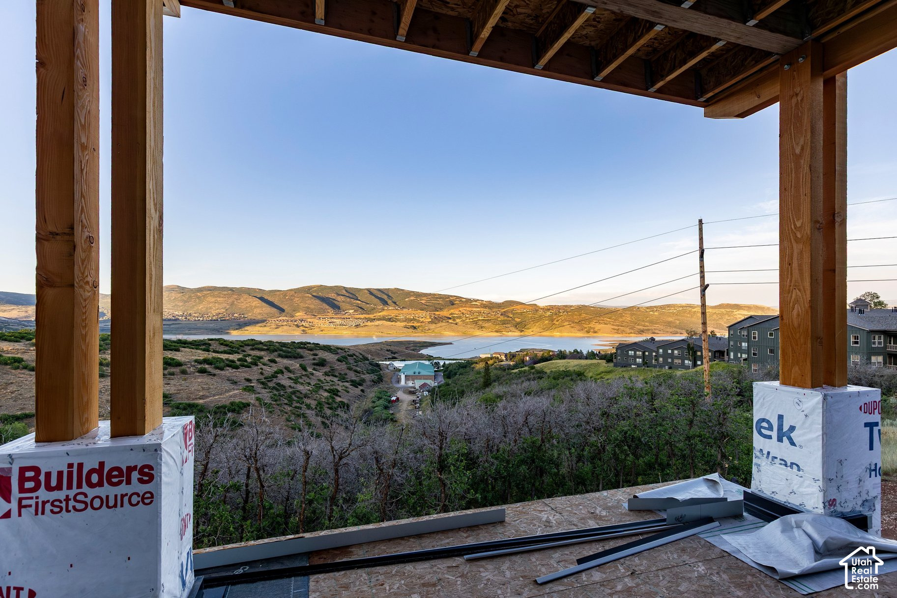 Mountain and lake view framed by exposed timber beams at a home under construction.