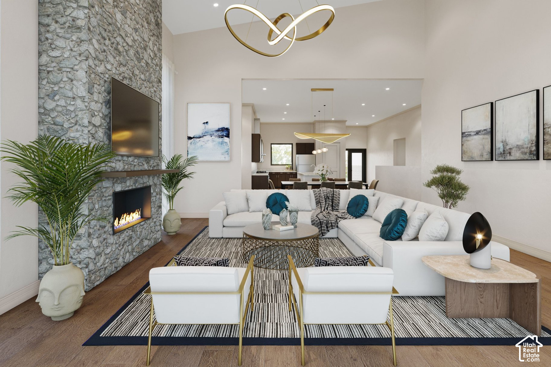 Living room with a stone fireplace, white sectional, and open kitchen and dining area.