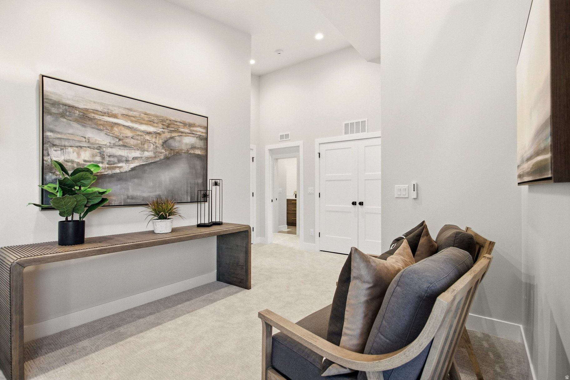 Furnished entry hall with a wood console, abstract artwork, and cushioned bench.