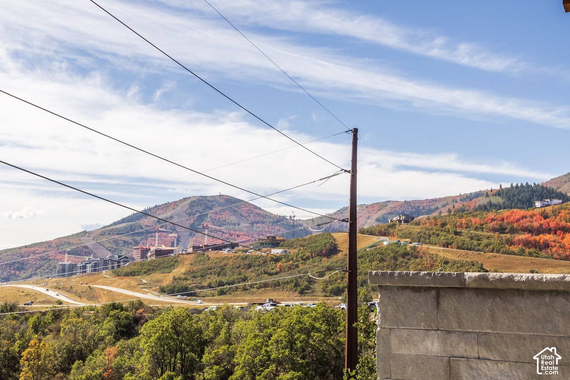Autumn mountain view with colorful hillsides and homes under construction.