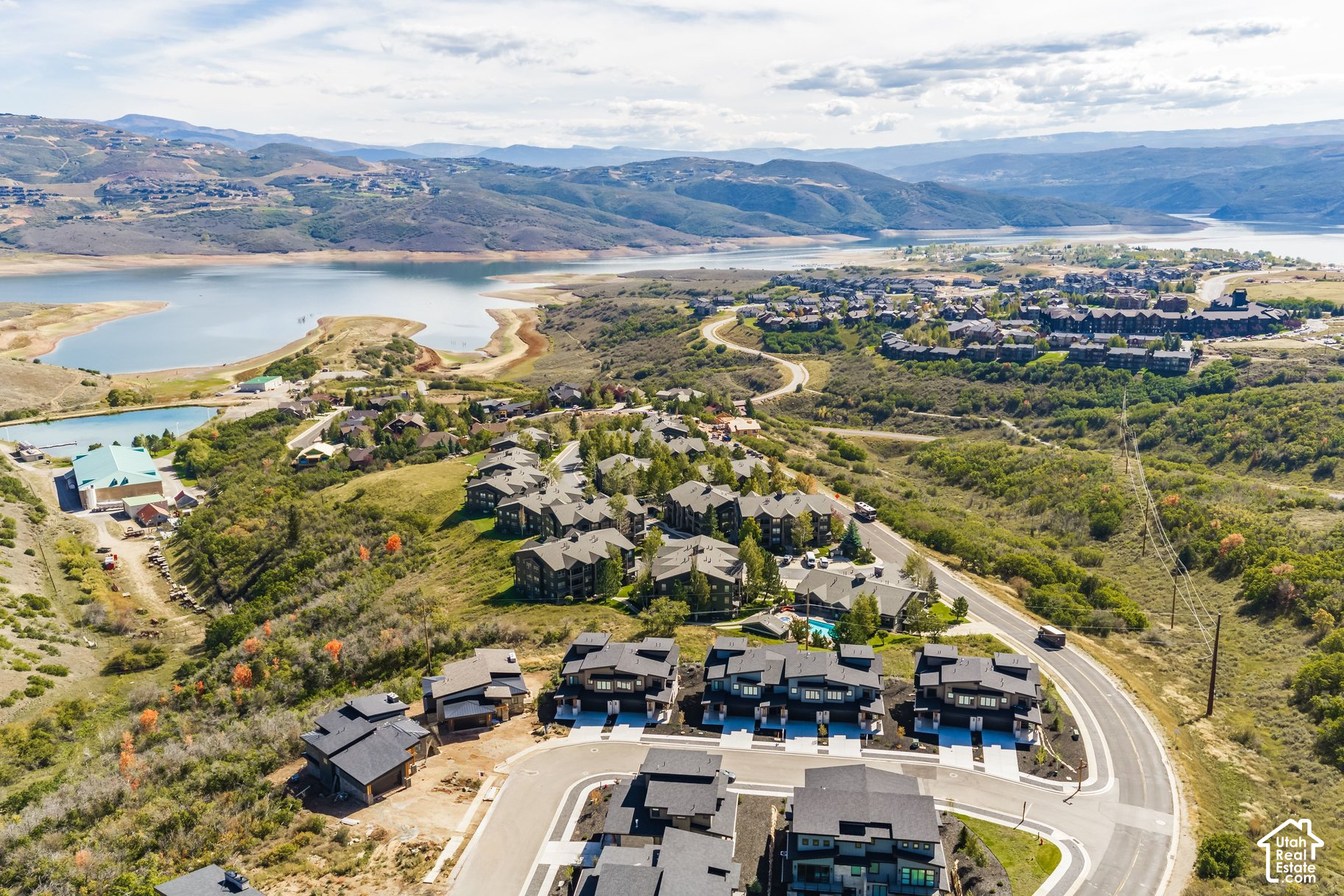 Aerial view of homes beside a reservoir, with rolling mountains in the distance.