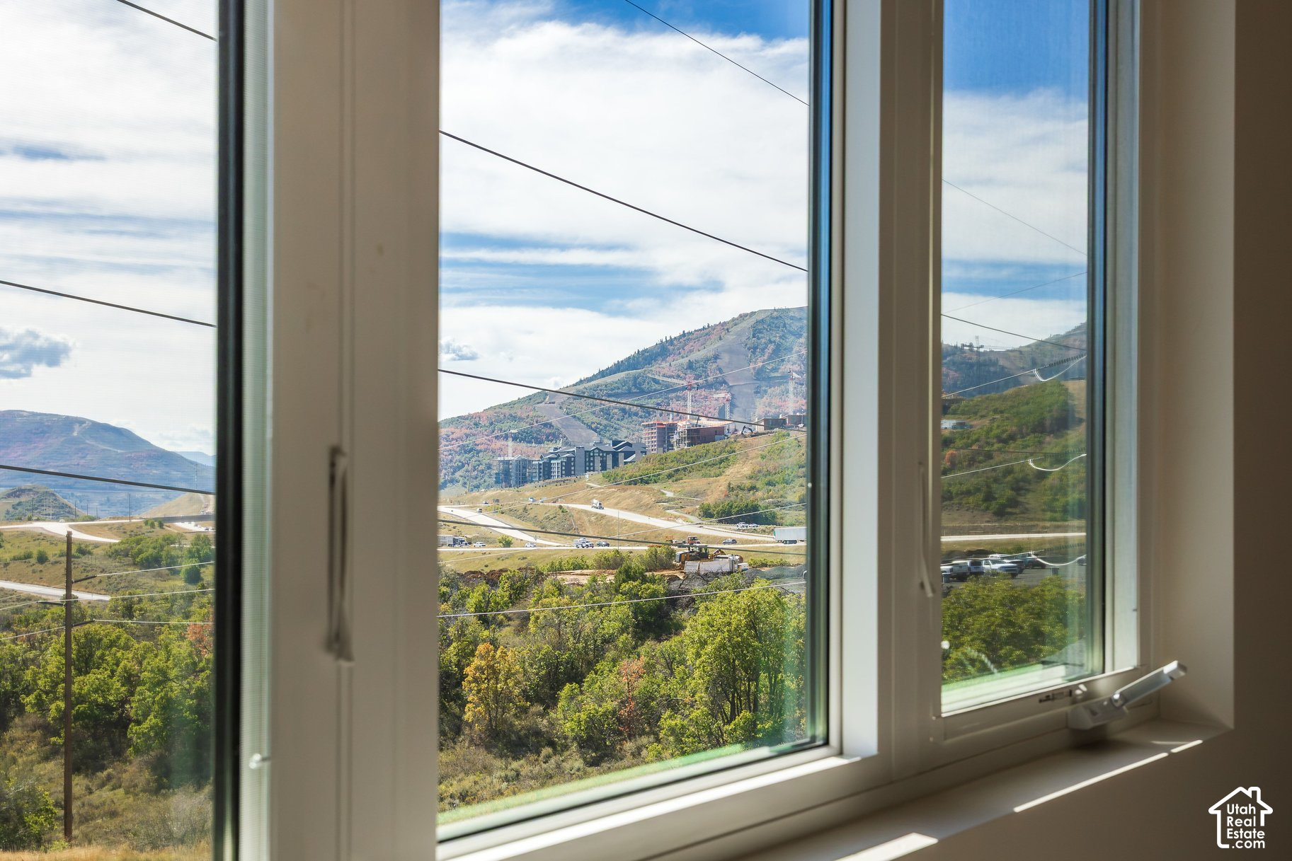 Mountain hills and autumn foliage seen through large windows.