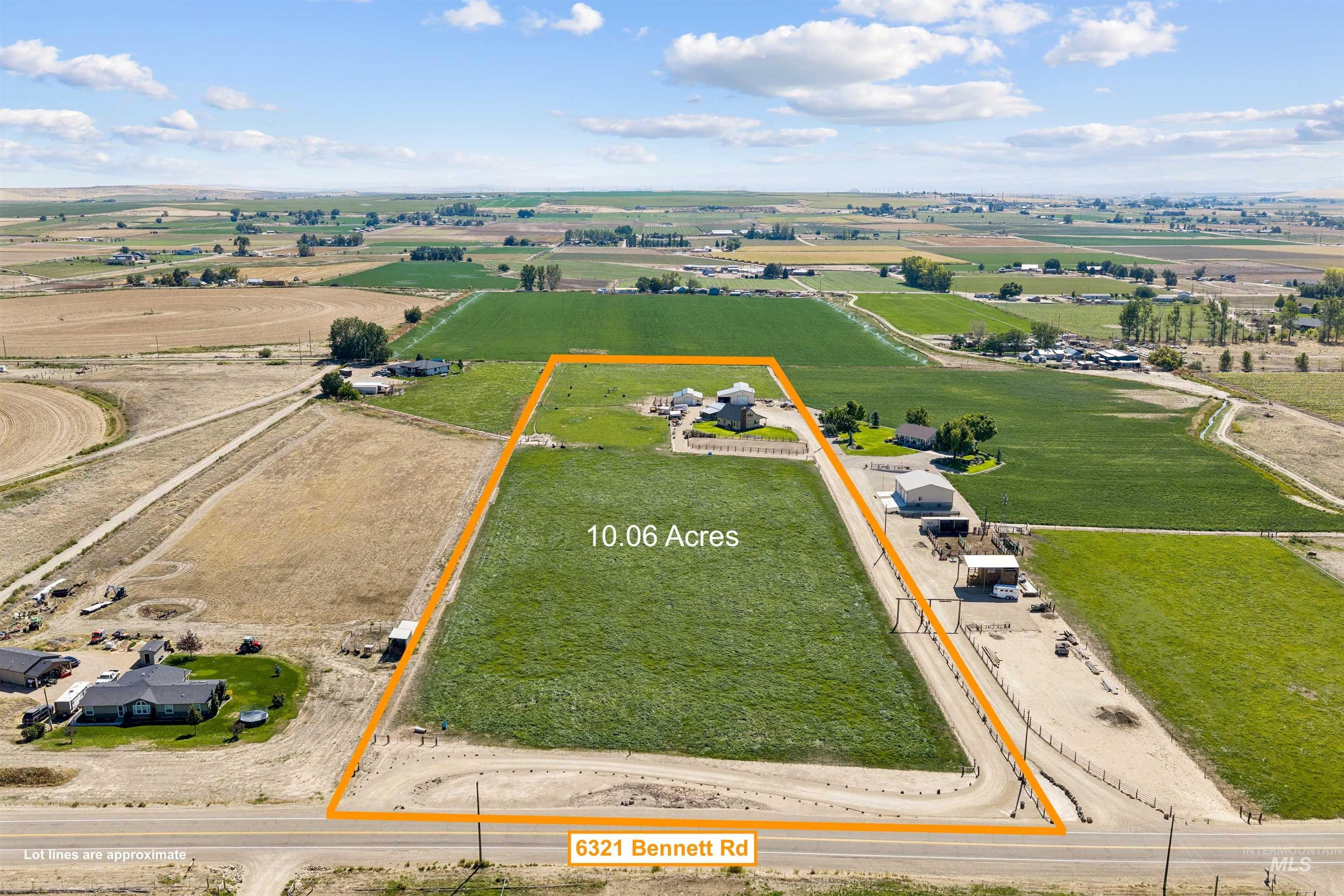 Aerial view of a 10.06-acre rural property outlined in orange, with a home, outbuildings, and road frontage.