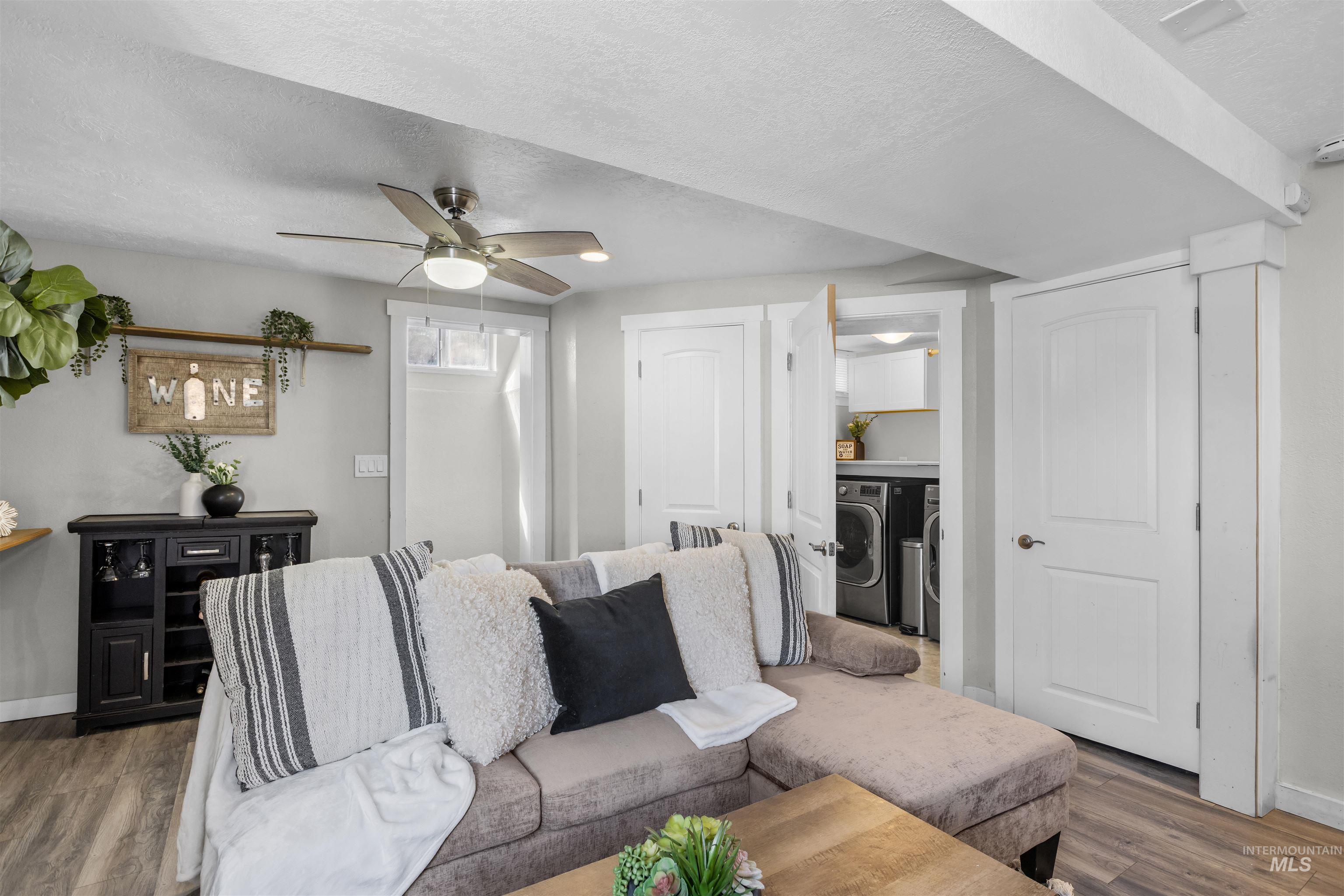 Living room with a gray sectional sofa and a view through the doorway to the laundry area.