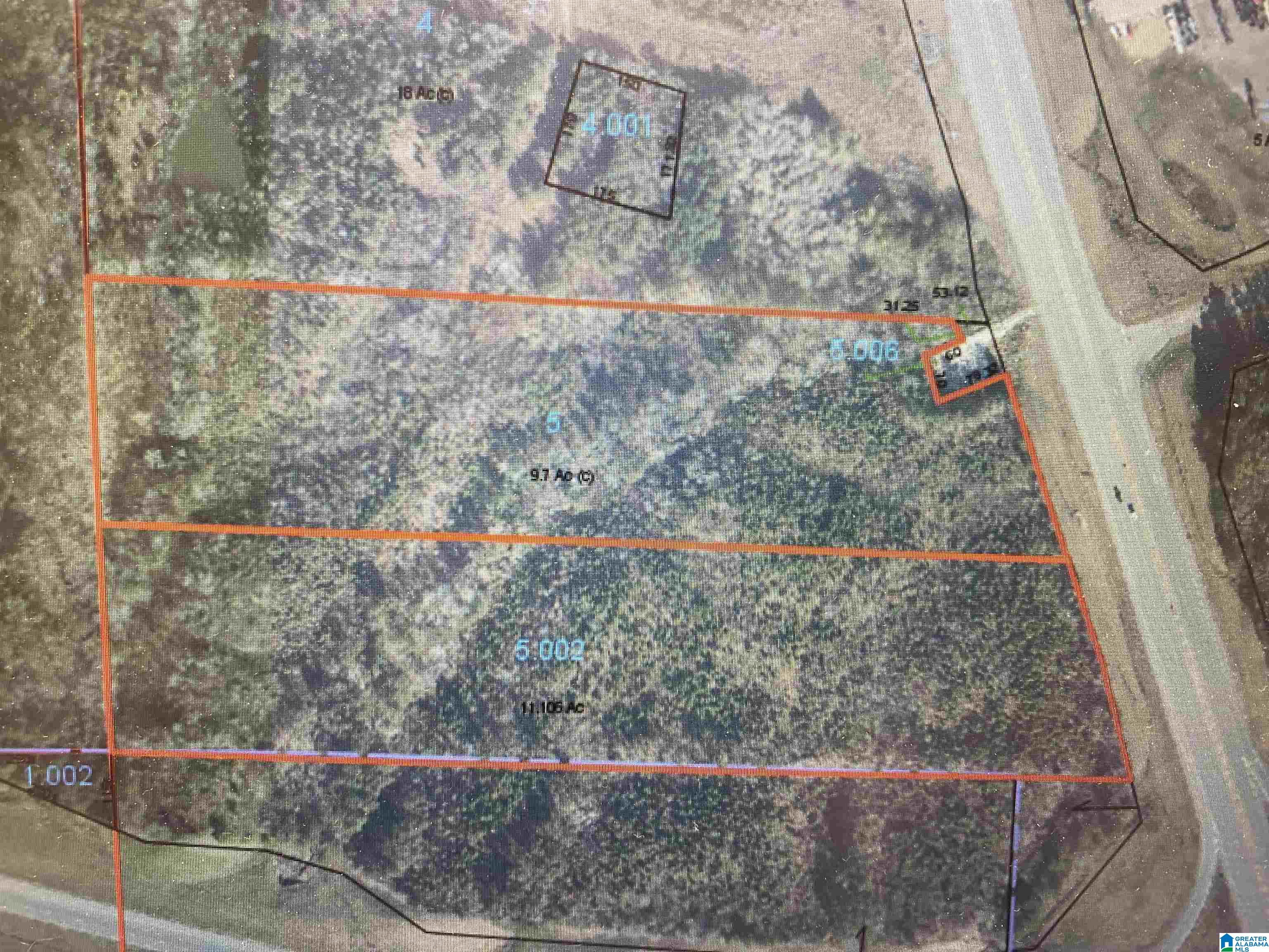 Aerial parcel map of wooded lots outlined in orange along a road.