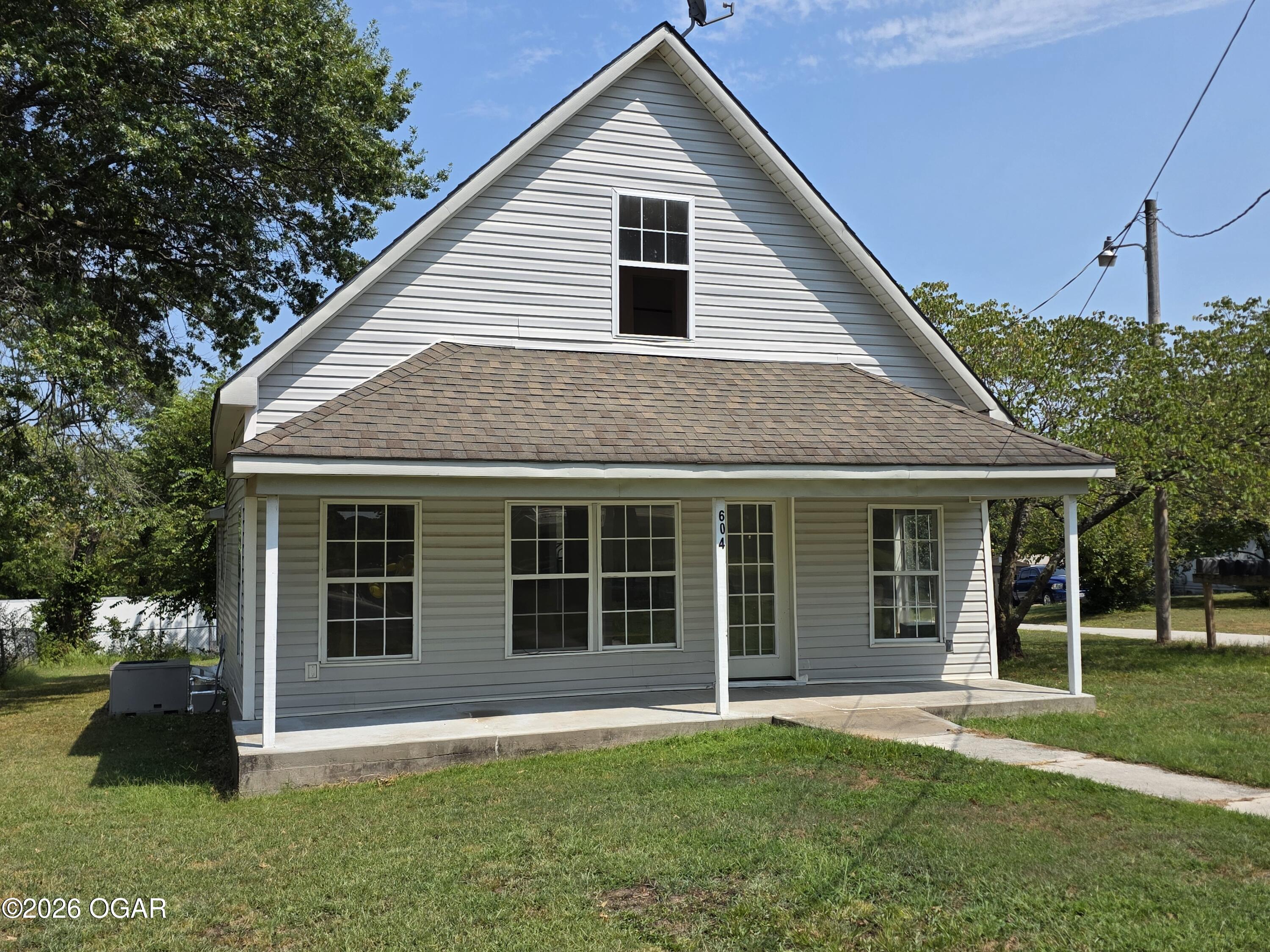 House with a steep front gable and covered porch, numbered 604 beside the entrance.