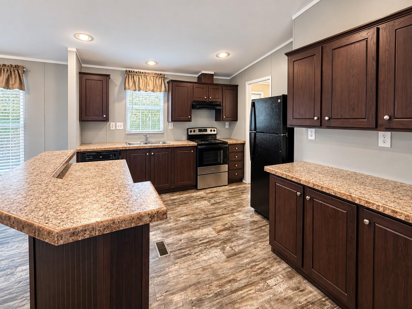 Kitchen with dark wood cabinetry, speckled countertops, and a large peninsula and island.