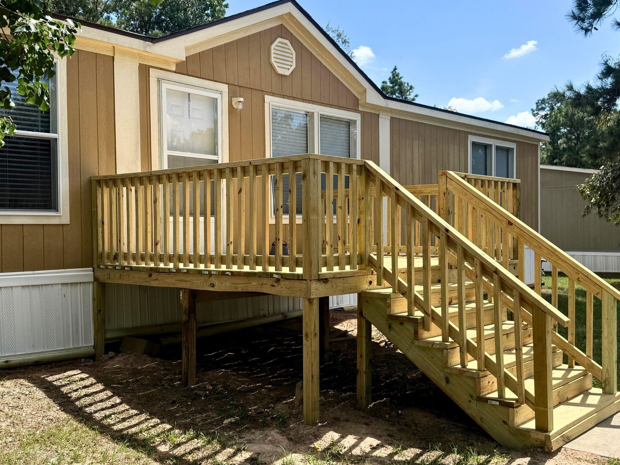 Raised wooden deck and long staircase along the tan home's exterior.