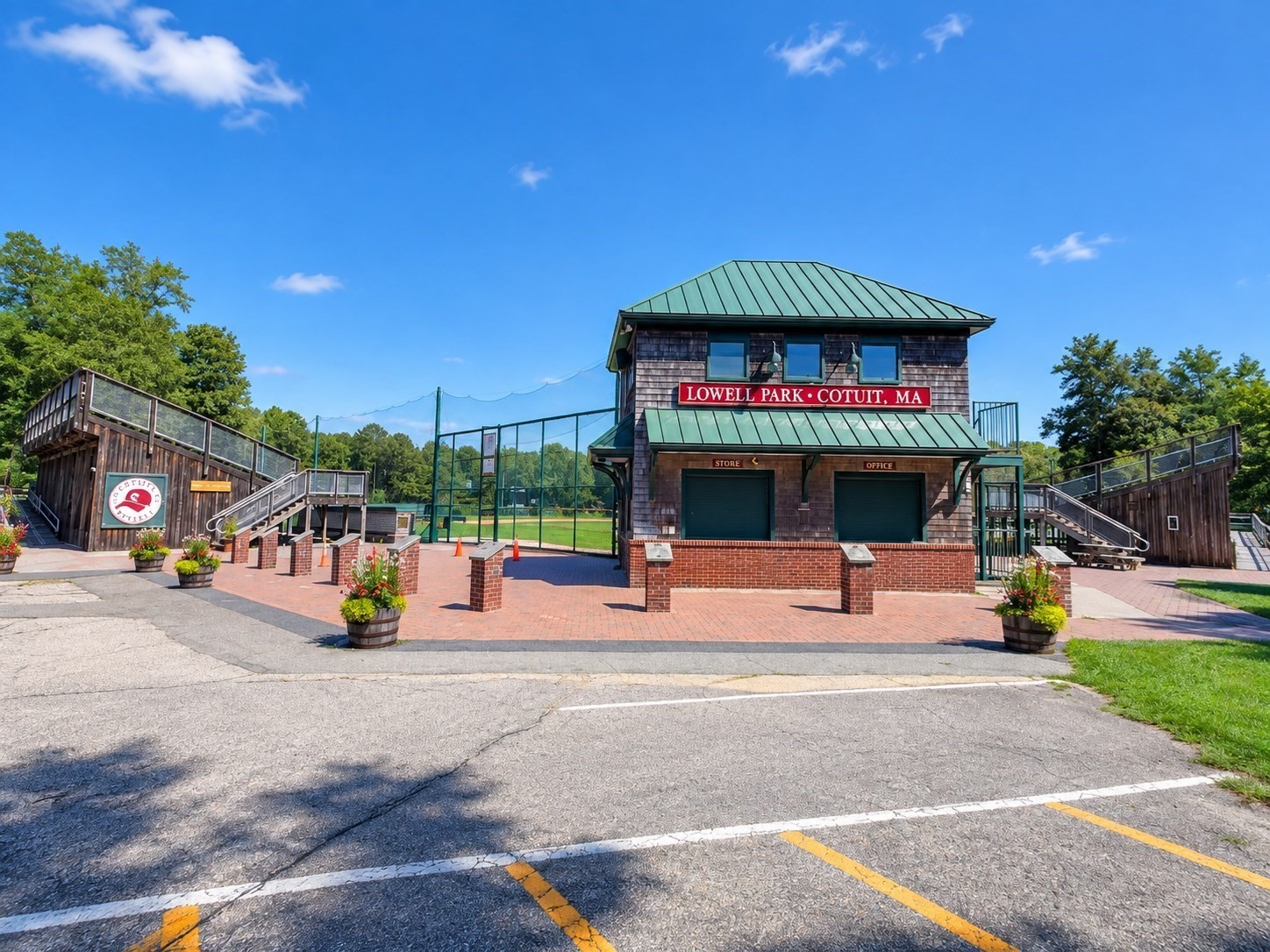 Lowell Park in Cotuit, with its shingled concession building, brick plaza, and wooden stands.