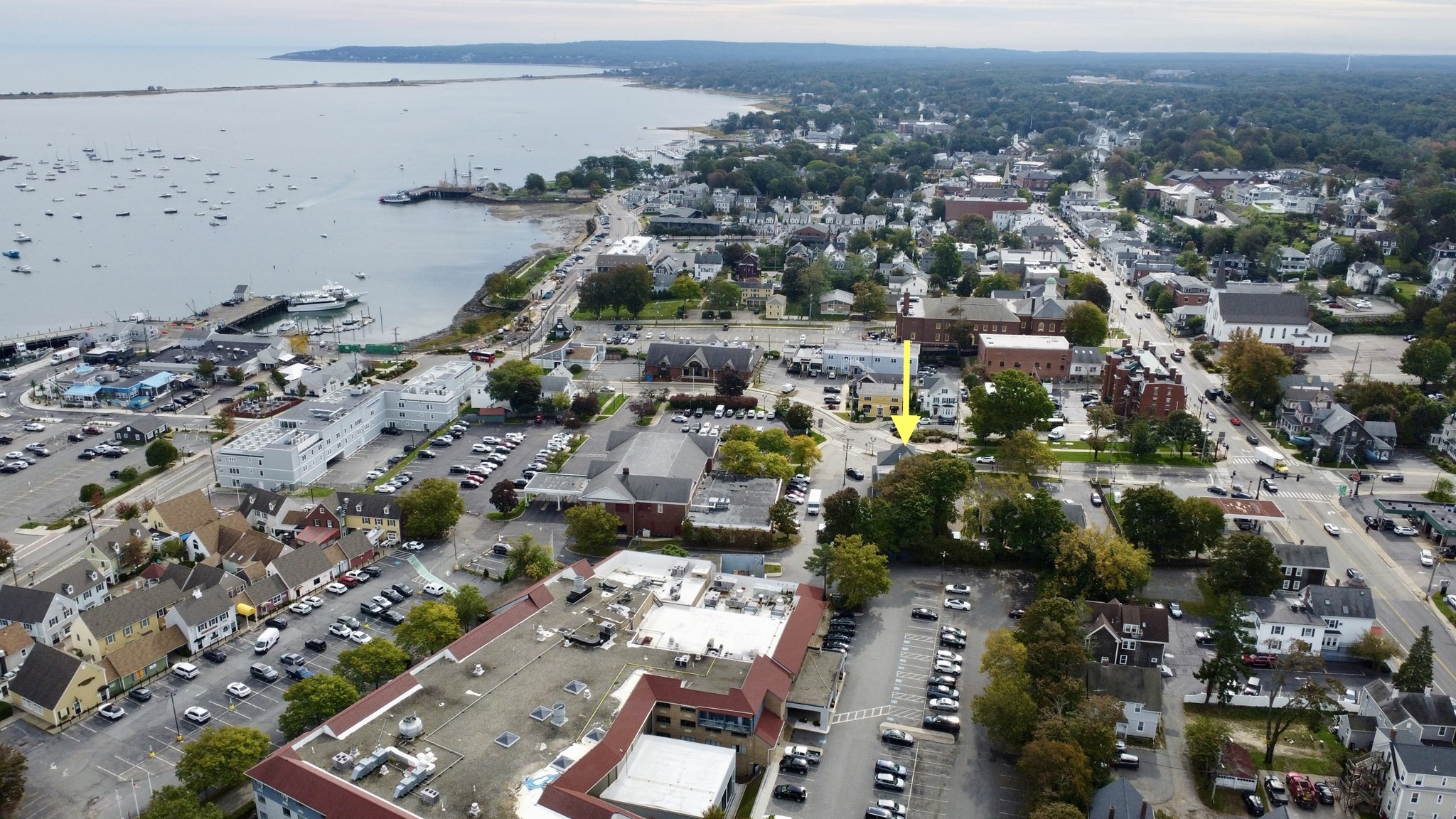 Aerial view of the marked property in downtown Plymouth, with Plymouth Harbor and boats in the background.
