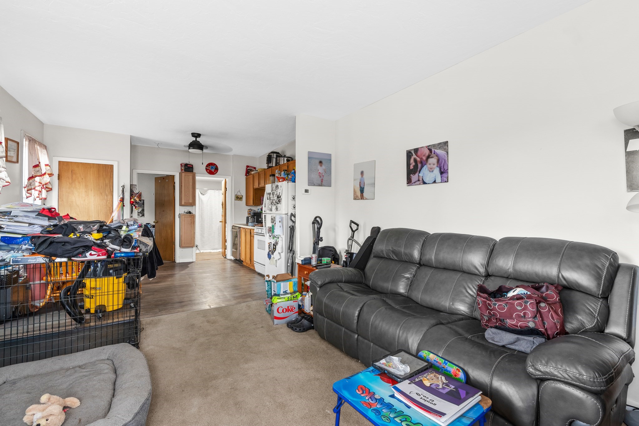 Living room with a large gray leather sectional, toys, and household items throughout.