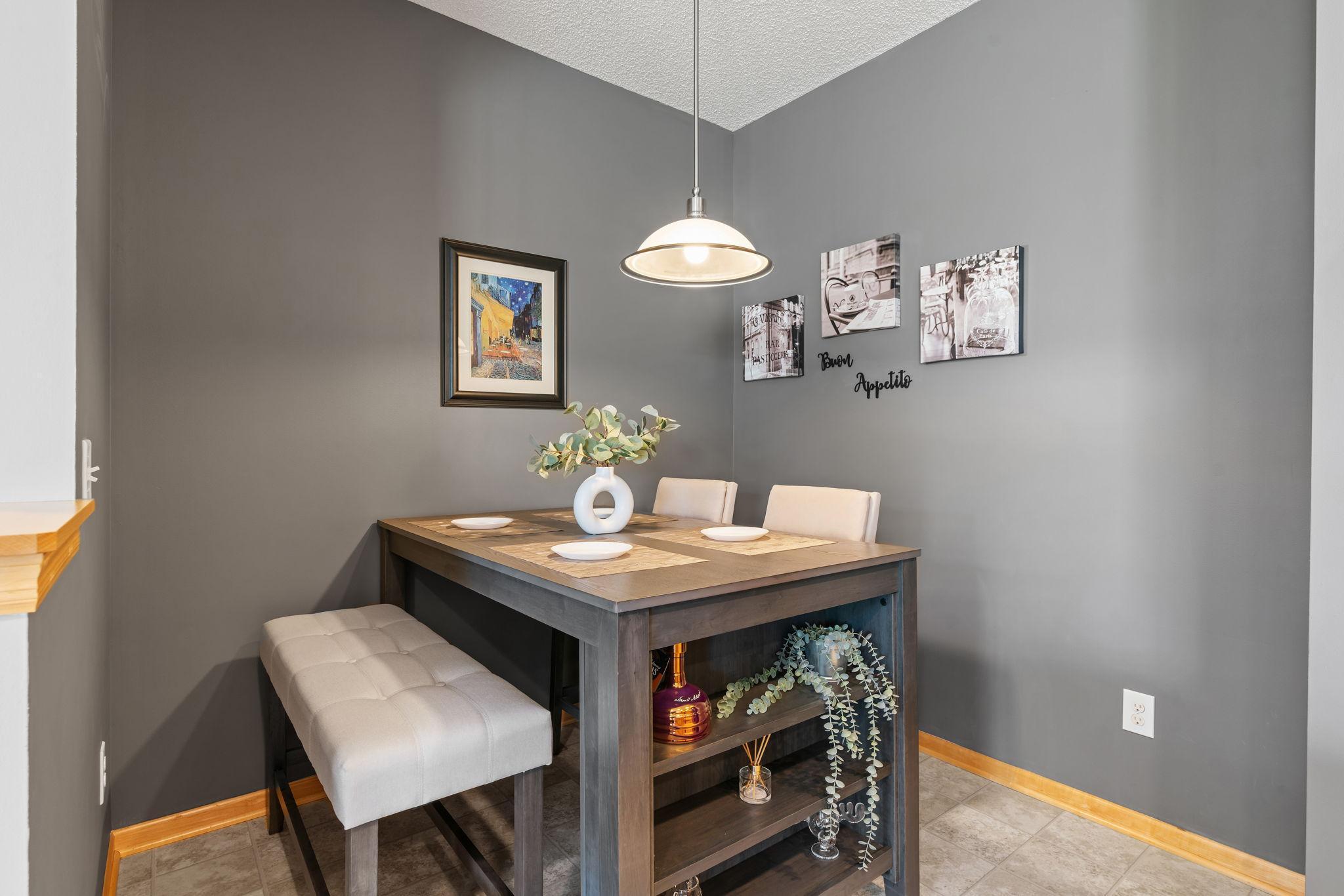 Dining area with a dark wood table, upholstered bench, and pendant light.