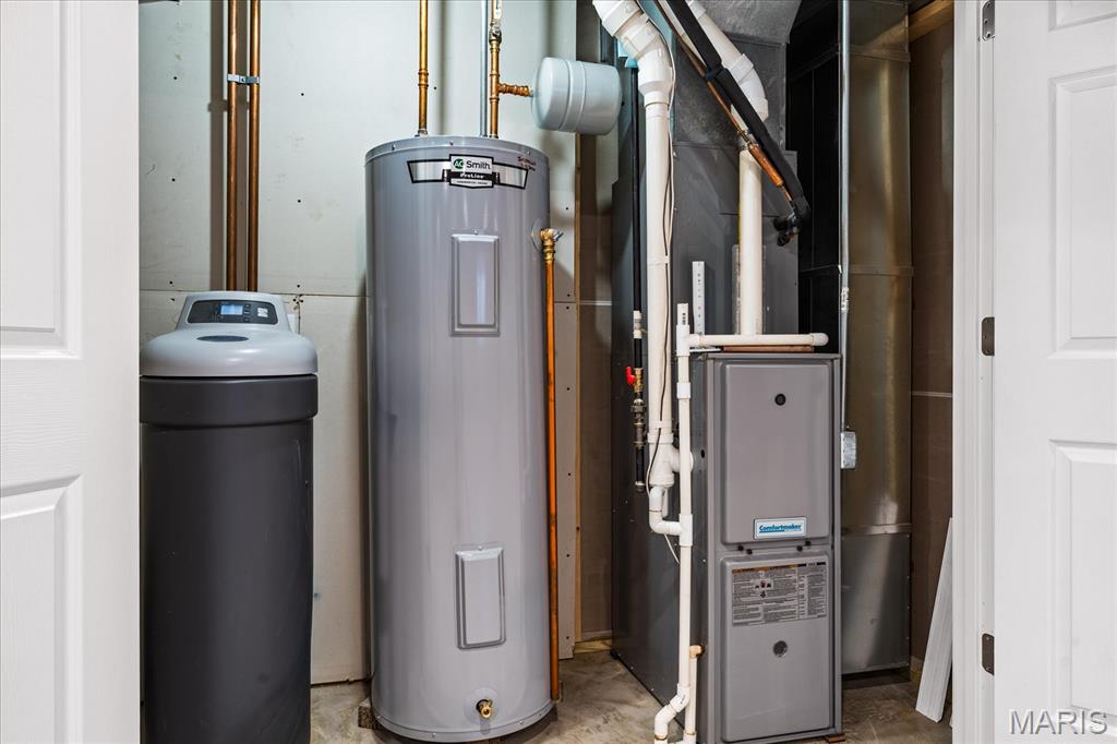 Utility room with a water heater, water softener, and furnace.