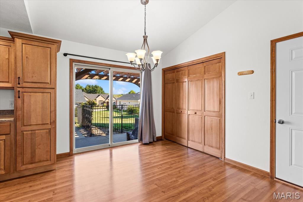 Bright room with wood cabinetry and hardwood floors, opening through sliding doors to a patio.