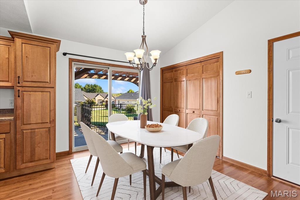 Dining room with a white table, wood cabinetry, and sliding glass doors to a fenced patio.