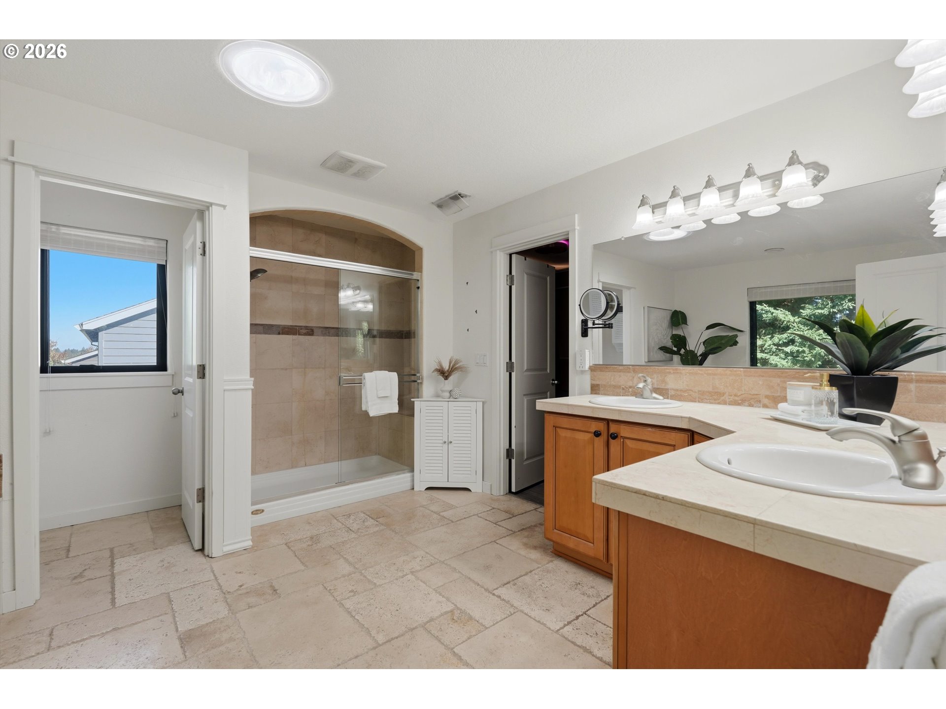 Bathroom with a tiled walk-in shower and double-sink wood vanity.