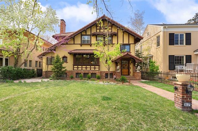 Tudor-style office building with a half-timbered facade, front lawn, and brick mailbox marked 317.