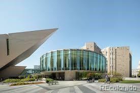 Modern building with a curved glass facade and landscaped grounds.