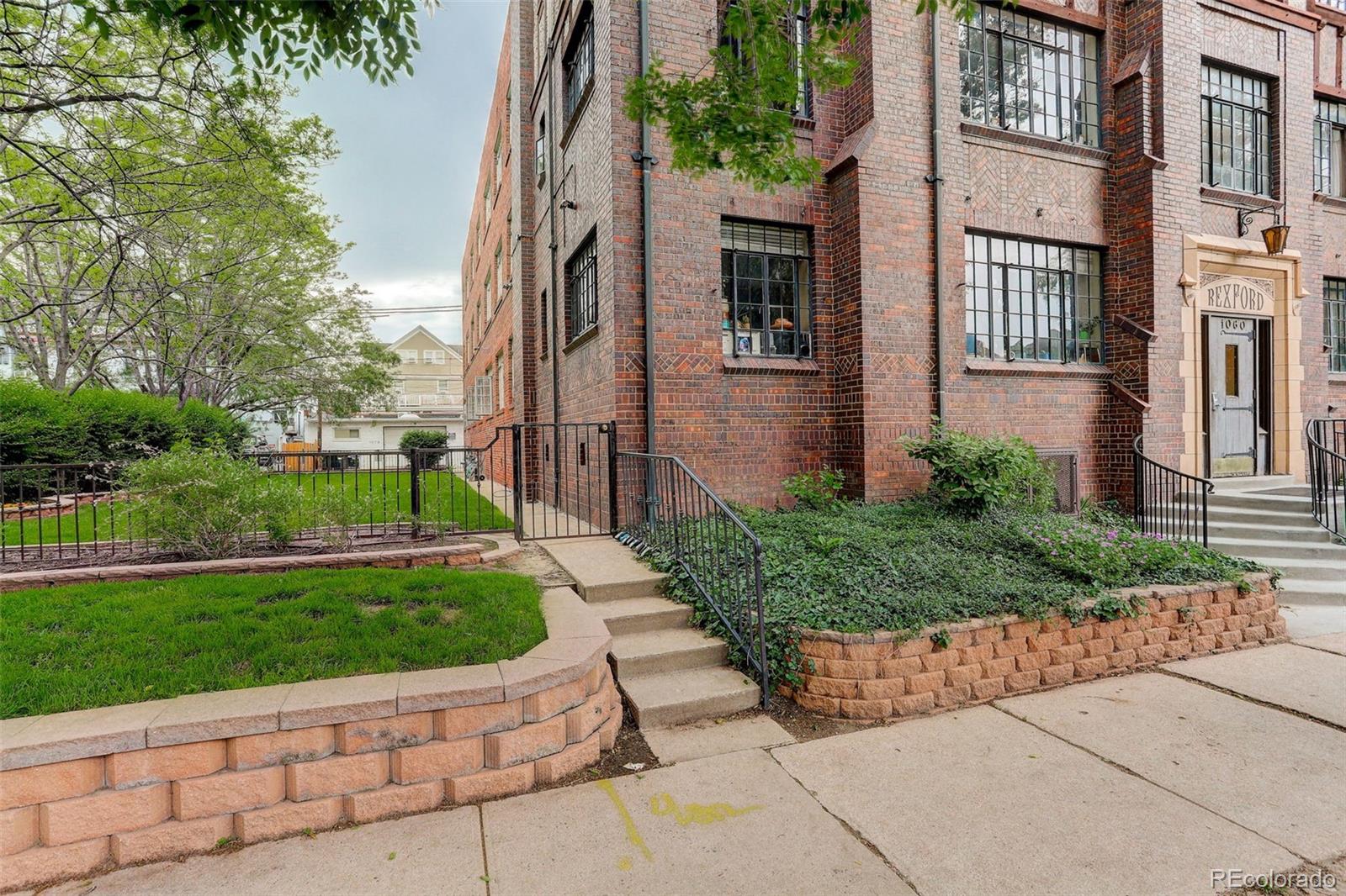 Brick Rexford building with landscaped grounds and a front entrance reached by steps.