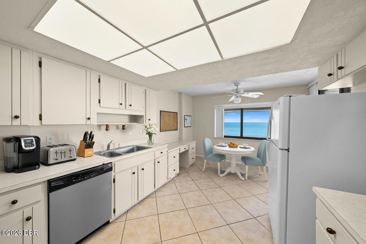 Kitchen with white cabinets and a breakfast table overlooking the ocean.