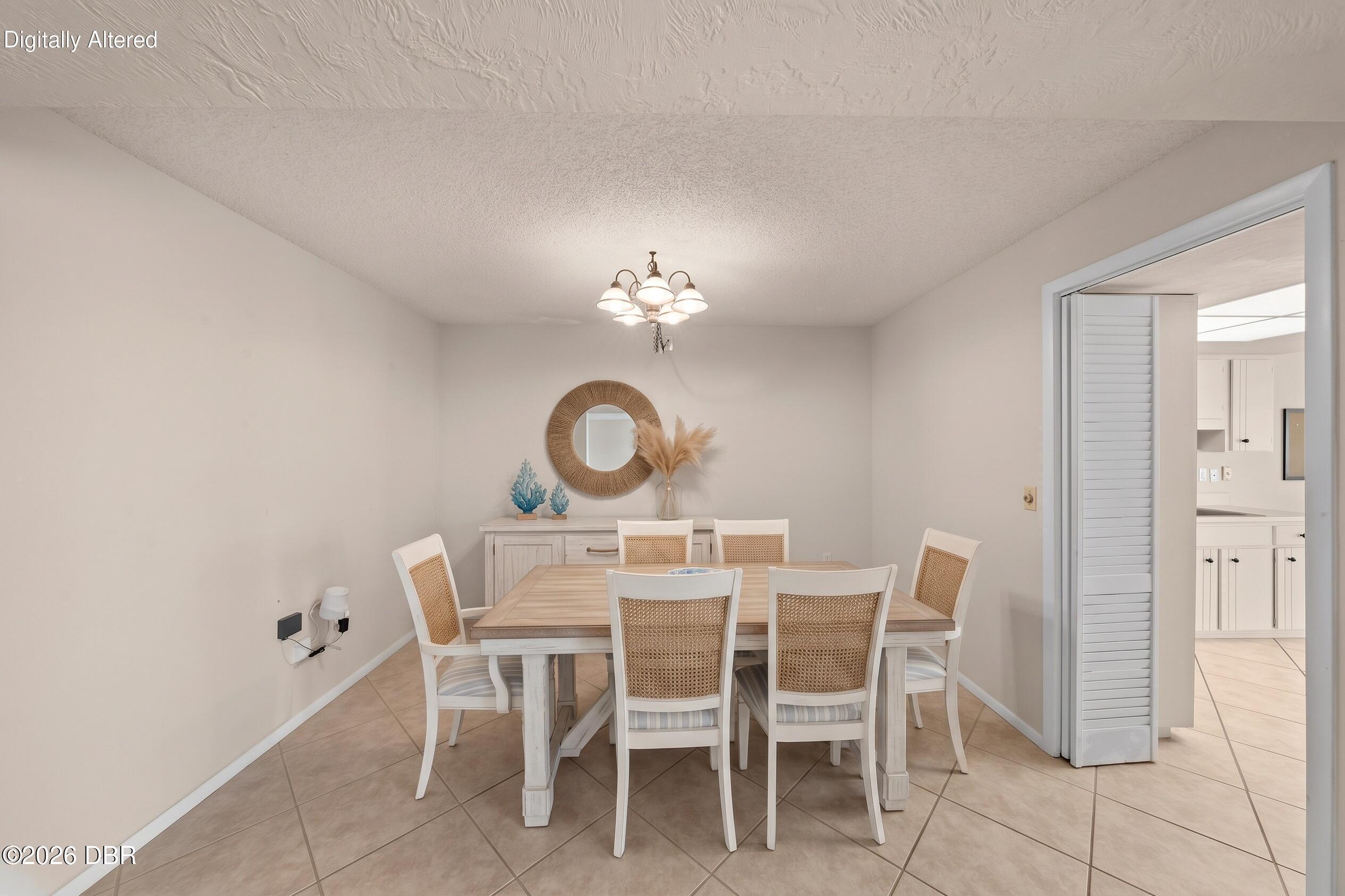 Dining room with a six-chair table, woven-back chairs, and coastal decor beside the kitchen.